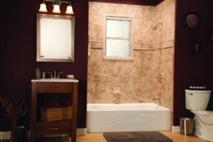 Bathroom with deep maroon walls features a small accent table, mirror, and low bathtub. 